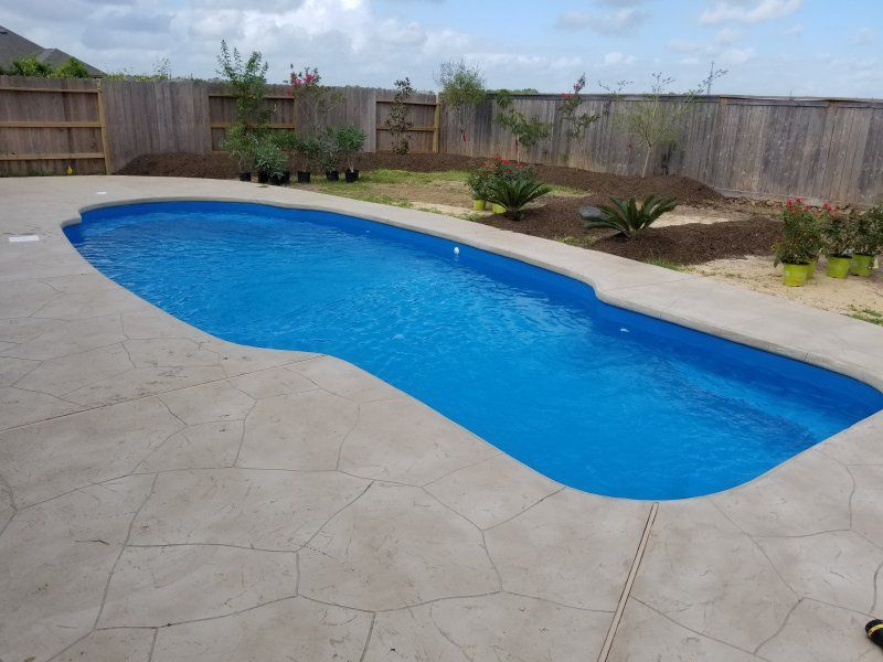 A large blue swimming pool with a fence in the background