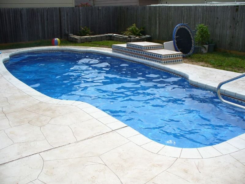 A large swimming pool with a fence in the background