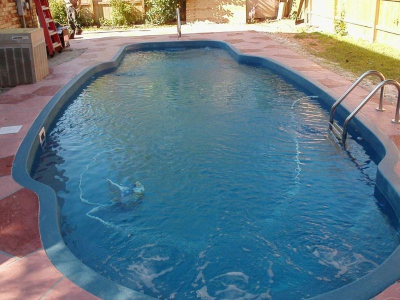 A large blue swimming pool with stairs leading to it