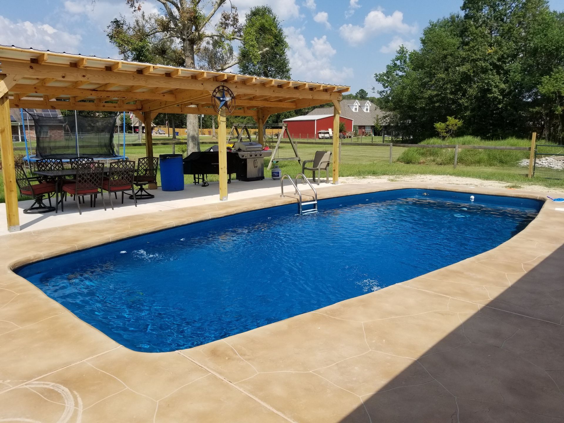A large swimming pool with a pergola over it
