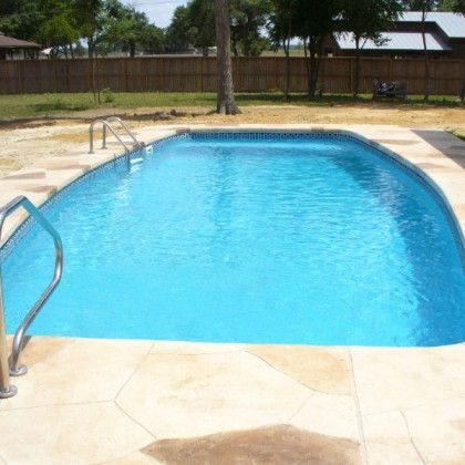 A large swimming pool with a fence in the background