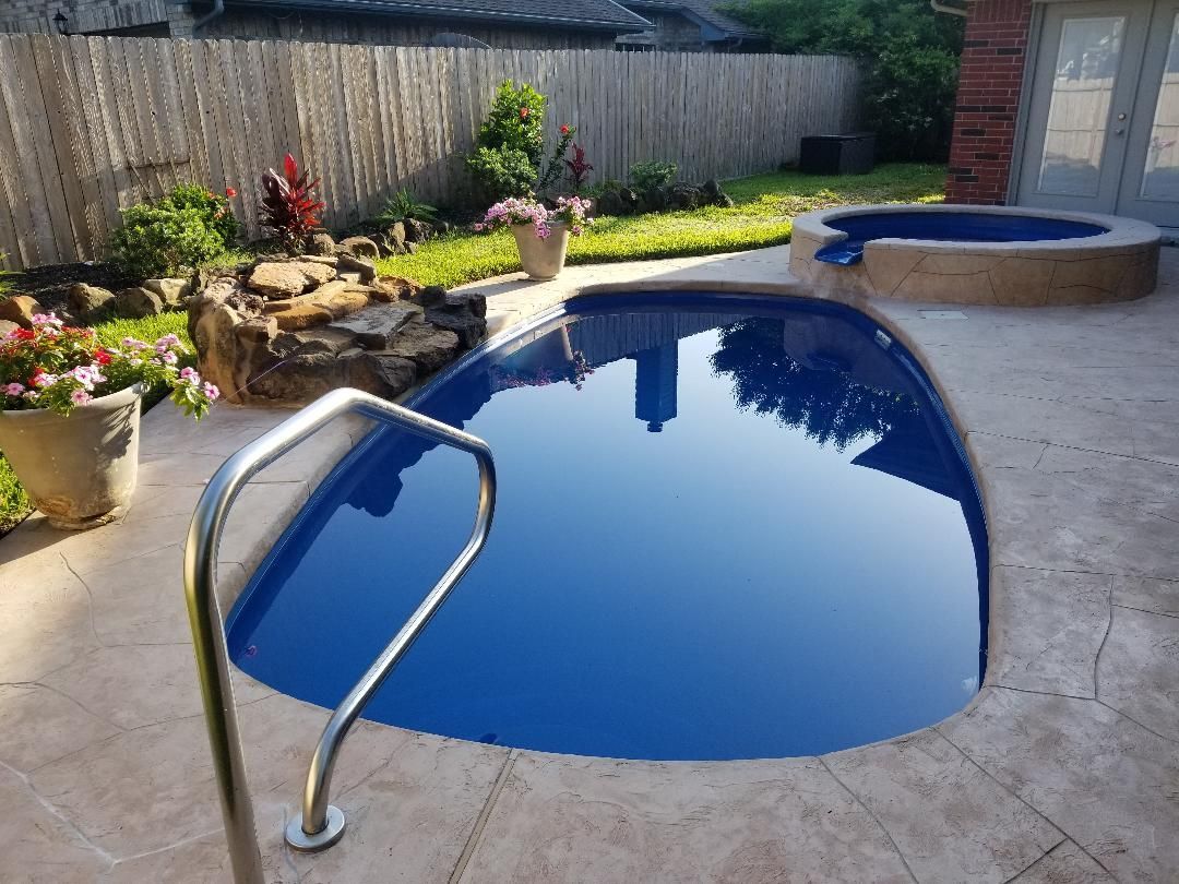 A swimming pool with a staircase leading to it in a backyard.