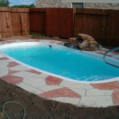 A swimming pool with a wooden fence in the background
