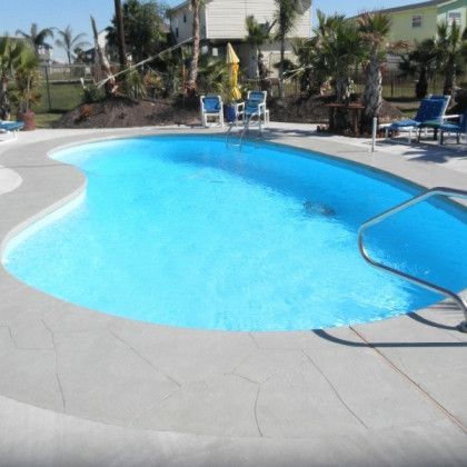 A large swimming pool surrounded by chairs and umbrellas