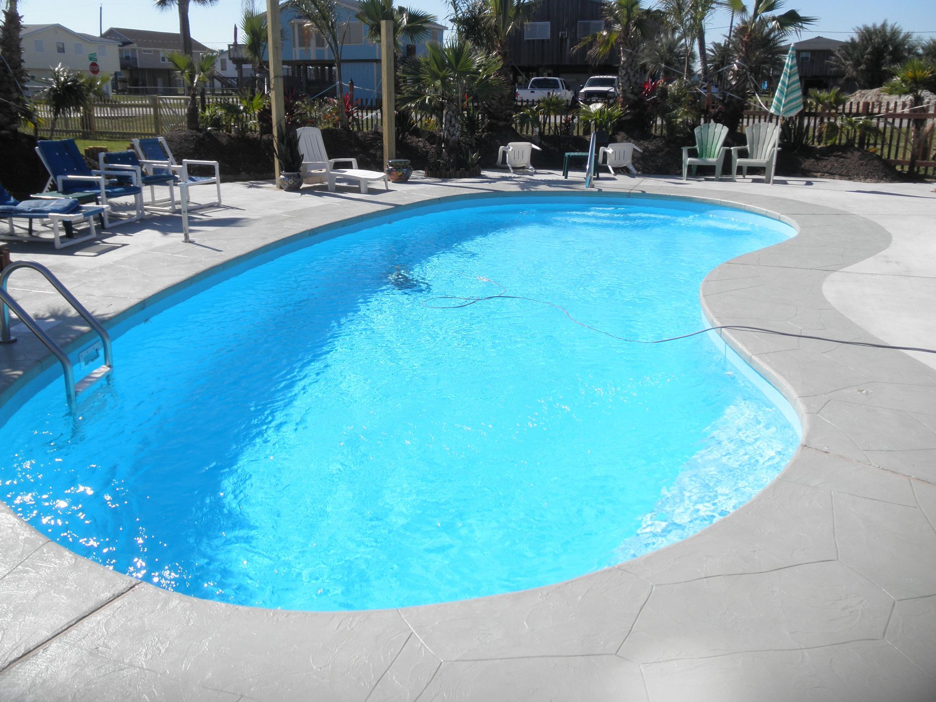 A large swimming pool surrounded by chairs and umbrellas