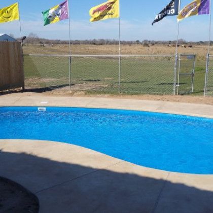 A swimming pool surrounded by flags including one that says jd