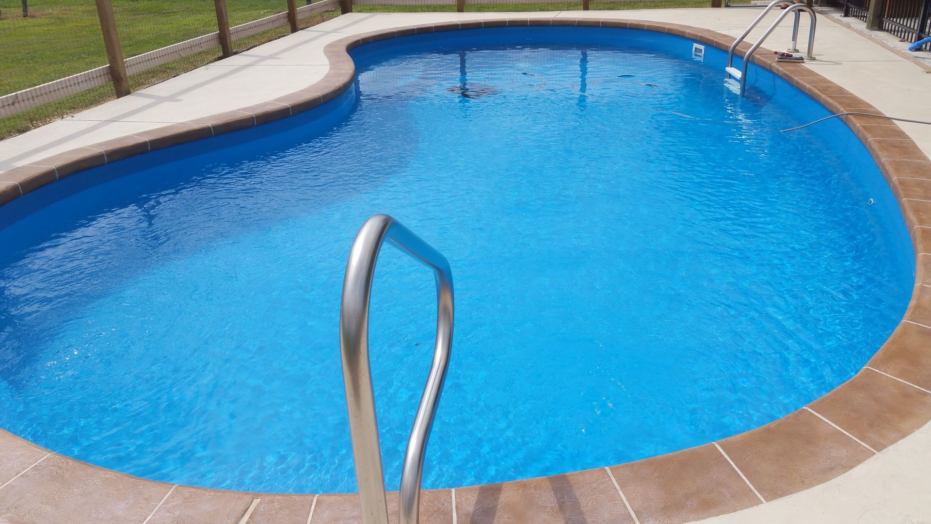 A large swimming pool with a staircase leading to it.