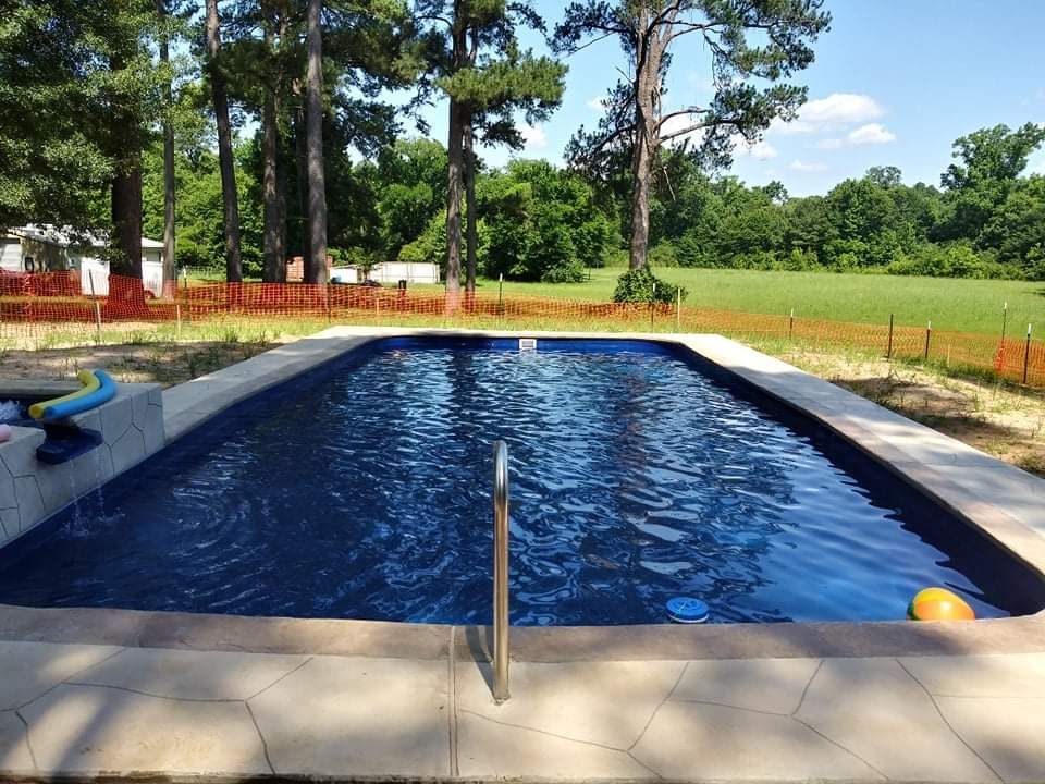 A large swimming pool with trees in the background