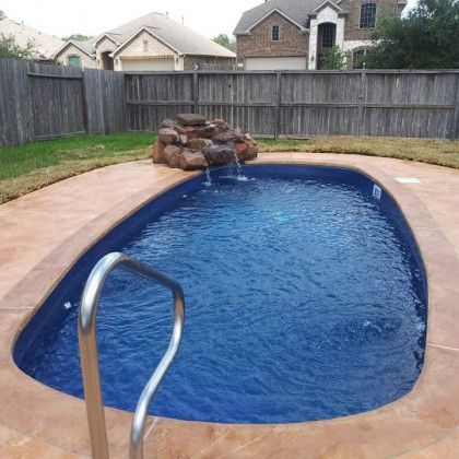 A swimming pool with a waterfall in the middle of it