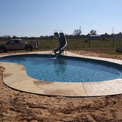 A large swimming pool with a slide in the middle of it.