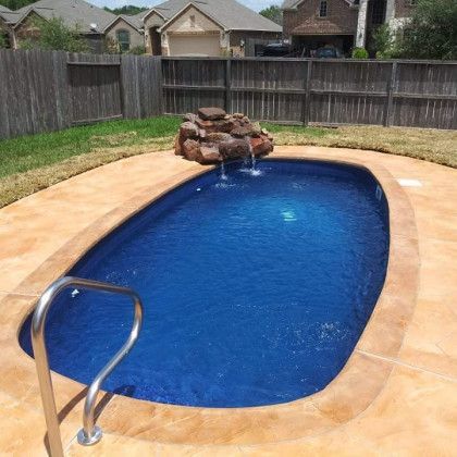 A small swimming pool with a waterfall in the middle of it