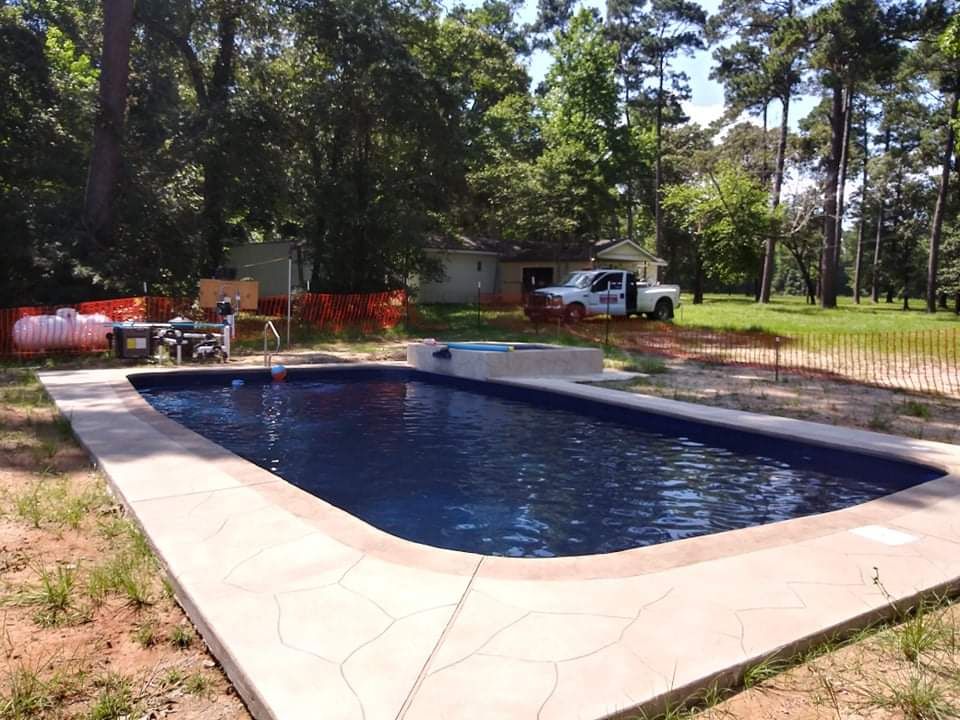 A white truck is parked next to a large swimming pool