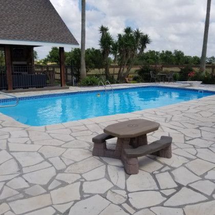 A large swimming pool with a picnic table in front of it