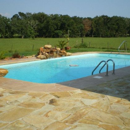 A large swimming pool with a waterfall in the background