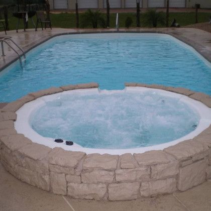 A large swimming pool with a jacuzzi in the middle