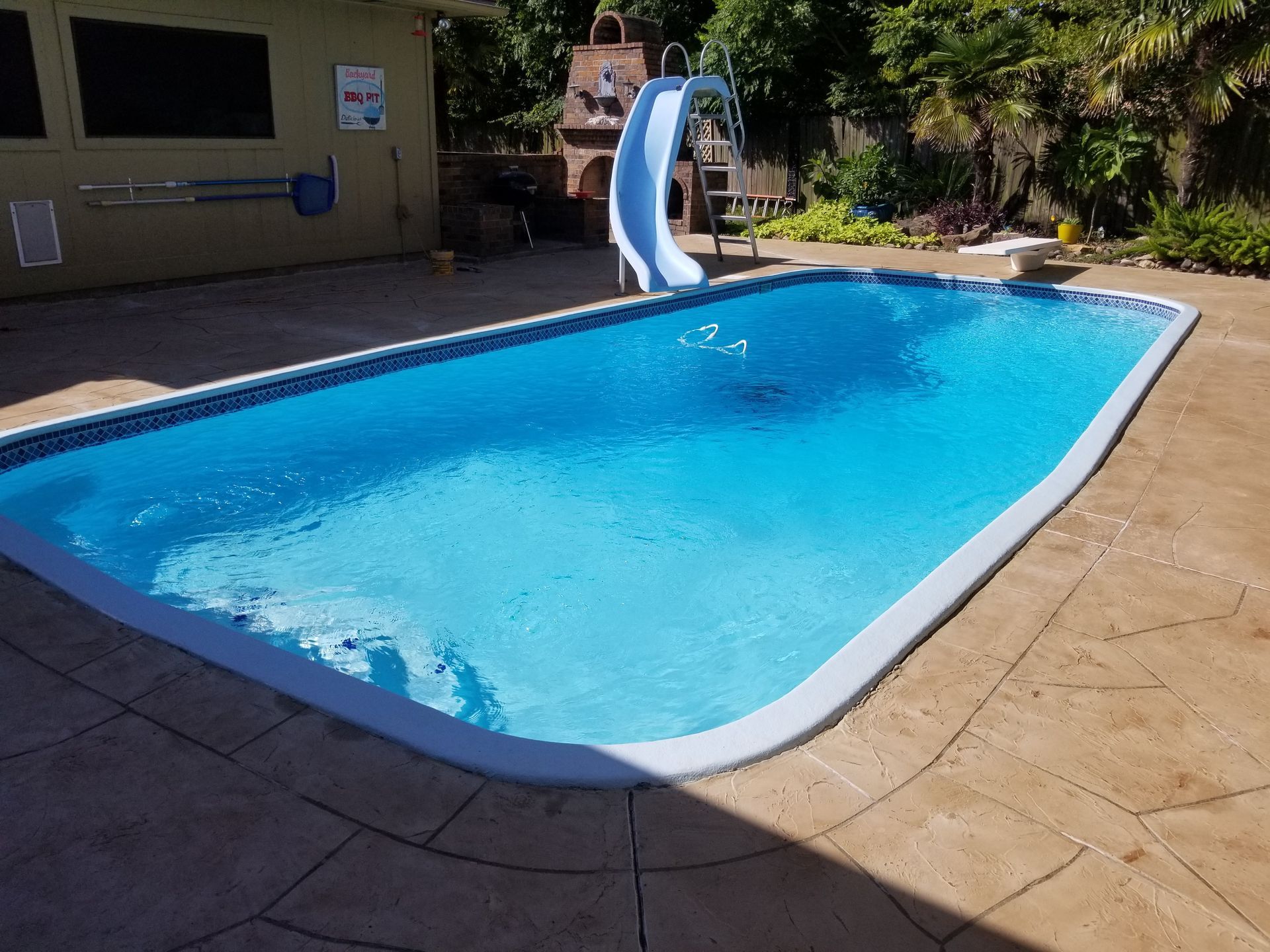 A large swimming pool with a slide attached to it