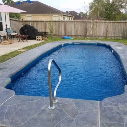 A large swimming pool with a staircase leading to it in a backyard.