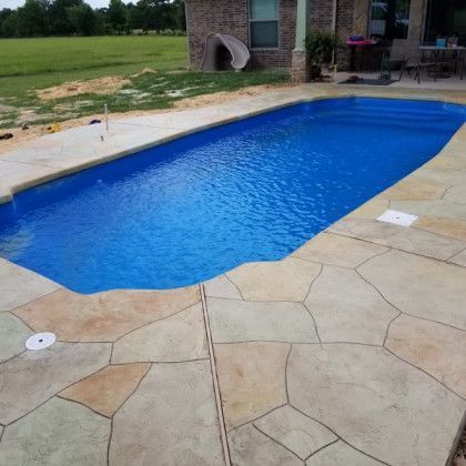 A large blue swimming pool with a slide in the background.