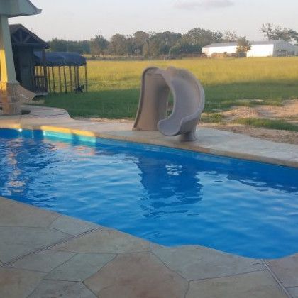 A swimming pool with a slide in the middle of it