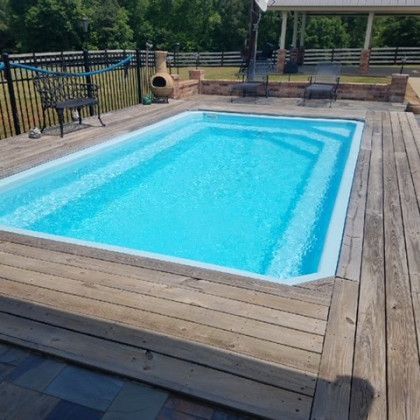 A large swimming pool surrounded by a wooden deck
