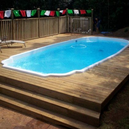 A large swimming pool sitting on top of a wooden deck