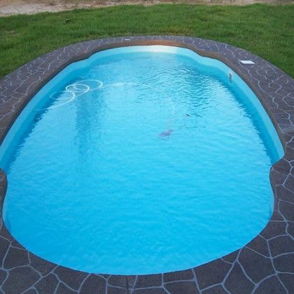 A large oval shaped swimming pool with blue water