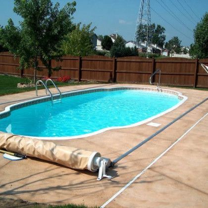 A swimming pool with a cover on it and a wooden fence in the background