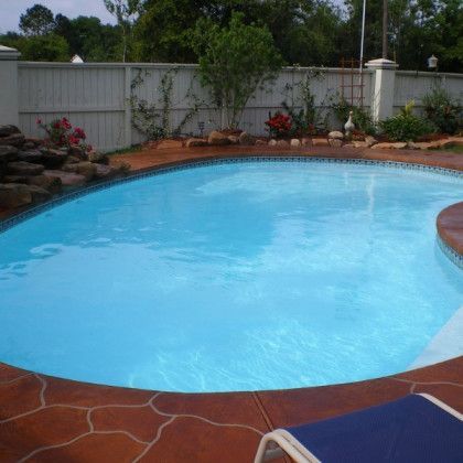 A large swimming pool with a fence in the background