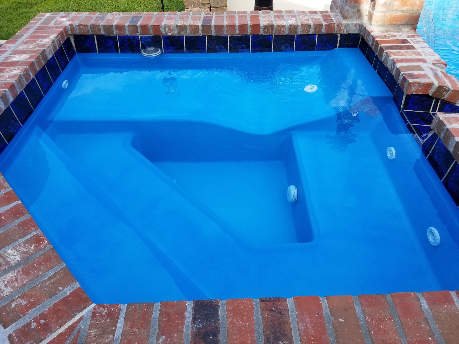 A large swimming pool is in the backyard of a house.