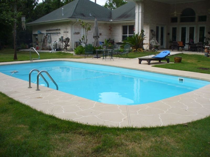 A large swimming pool in the backyard of a house