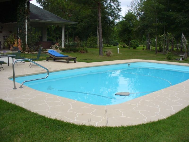 A large swimming pool in the backyard of a house