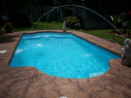 A swimming pool with a fountain in the middle of it