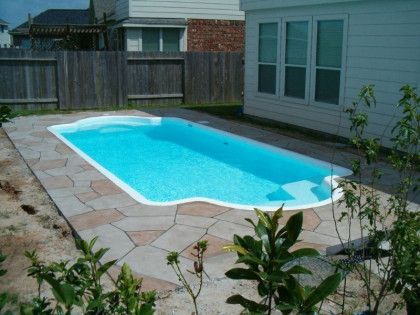 A large swimming pool in the backyard of a house