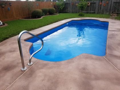 A swimming pool with a staircase leading to it in a backyard.