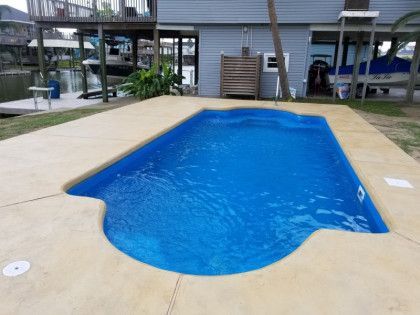 A large blue swimming pool in front of a house