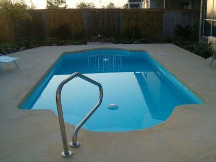 A small swimming pool with a staircase leading to it