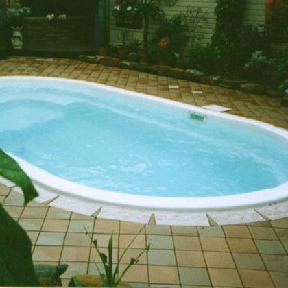 A large oval shaped swimming pool filled with blue water