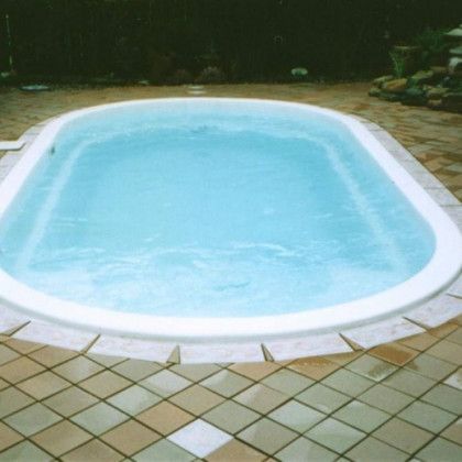 A large oval shaped swimming pool filled with blue water