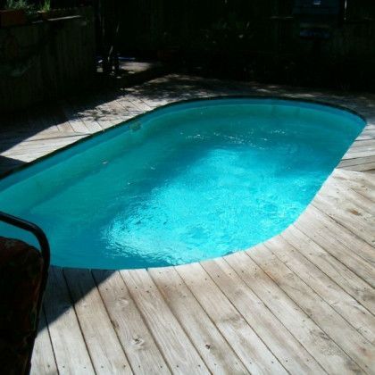 A large swimming pool is on a wooden deck