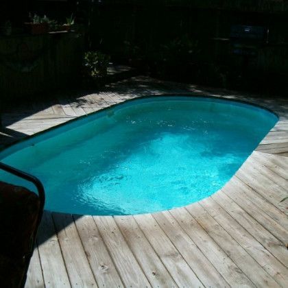 A large swimming pool is on a wooden deck