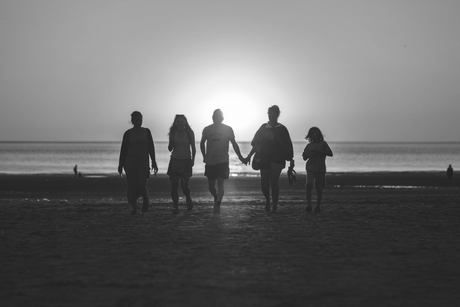 Famille sur la plage avec le soleil en arrière plan
