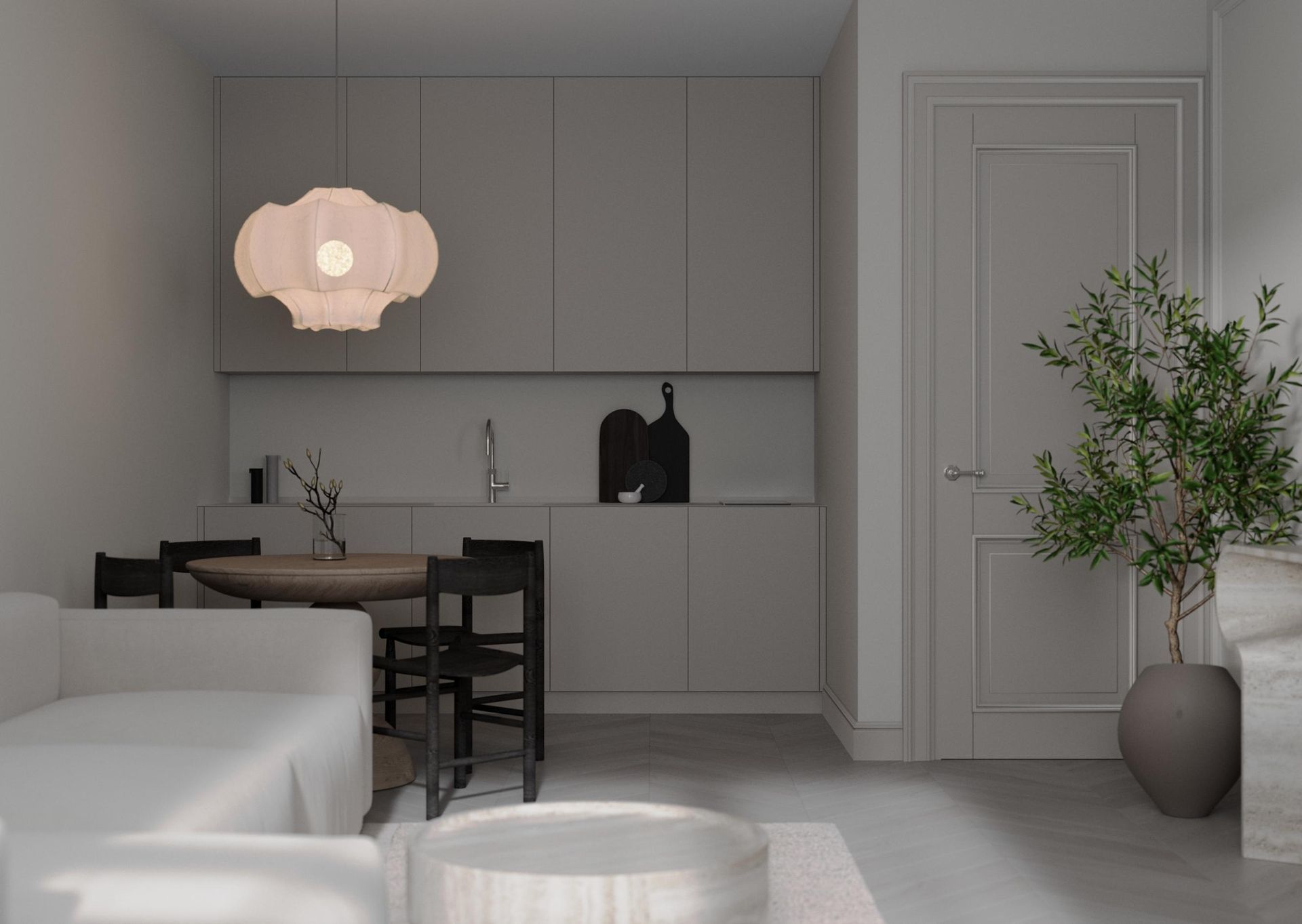 Modern minimalist kitchen and dining nook with pale cabinetry, pendant light, and a potted tree by the door