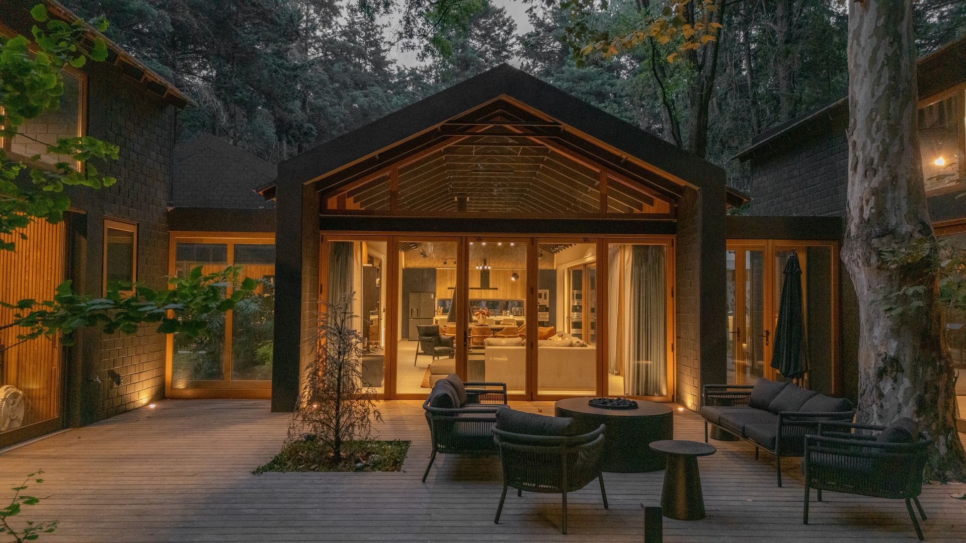 Modern two-story house with a garage, palm trees, and a pink sunset sky