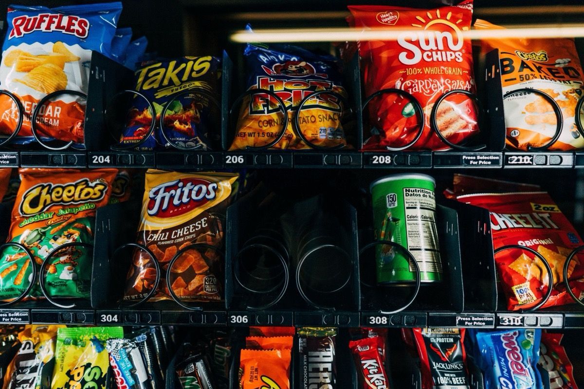 Convenience store snack shelf with chips and drinks in colorful bags and cans