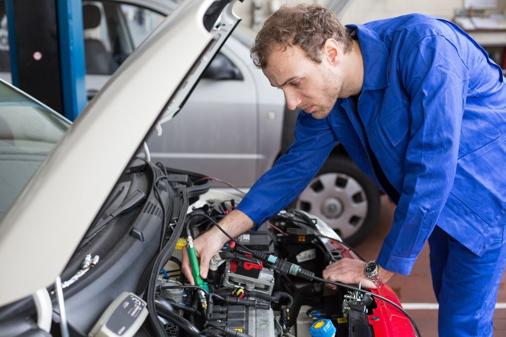 A Man Is Working on The Engine of A Car in A Garage — Carline Automotive Solutions in Bungalow, QLD