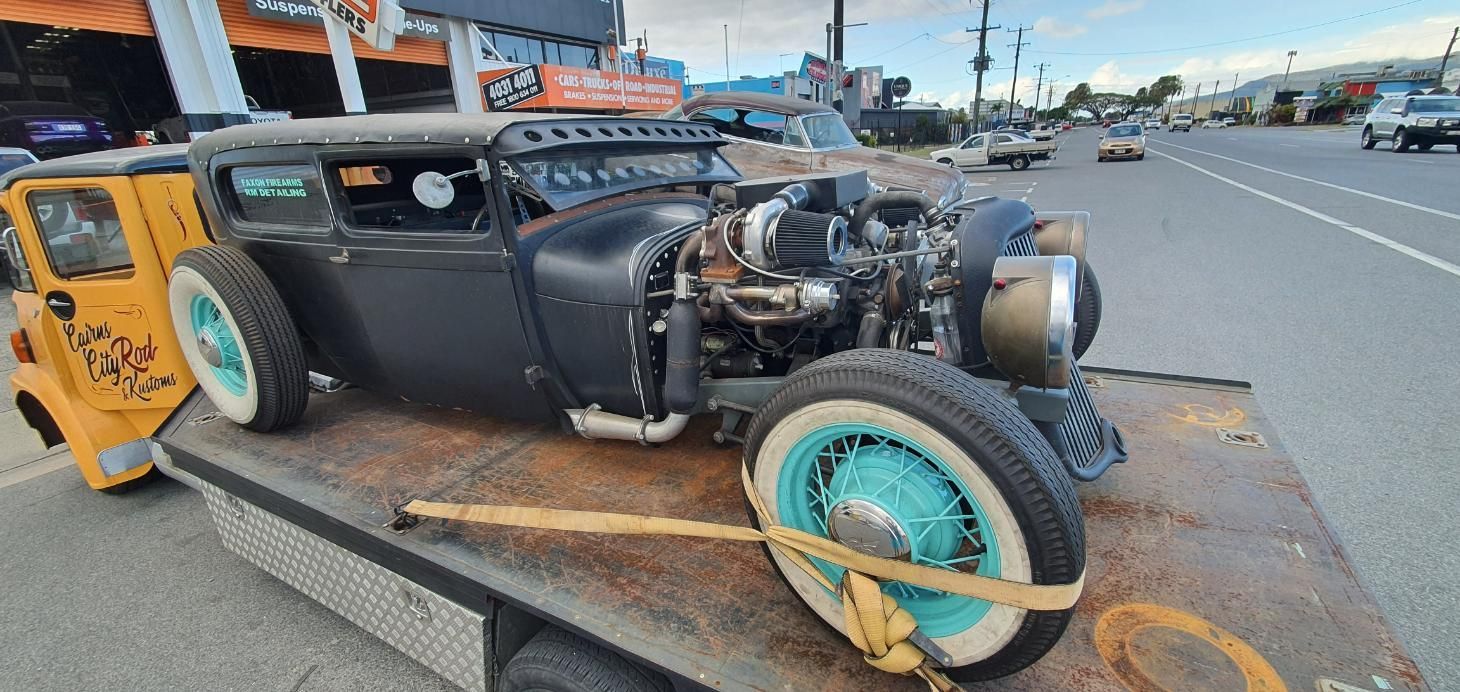 A Black Car Is Sitting on Top of A Tow Truck — Carline Automotive Solutions in Bungalow, QLD