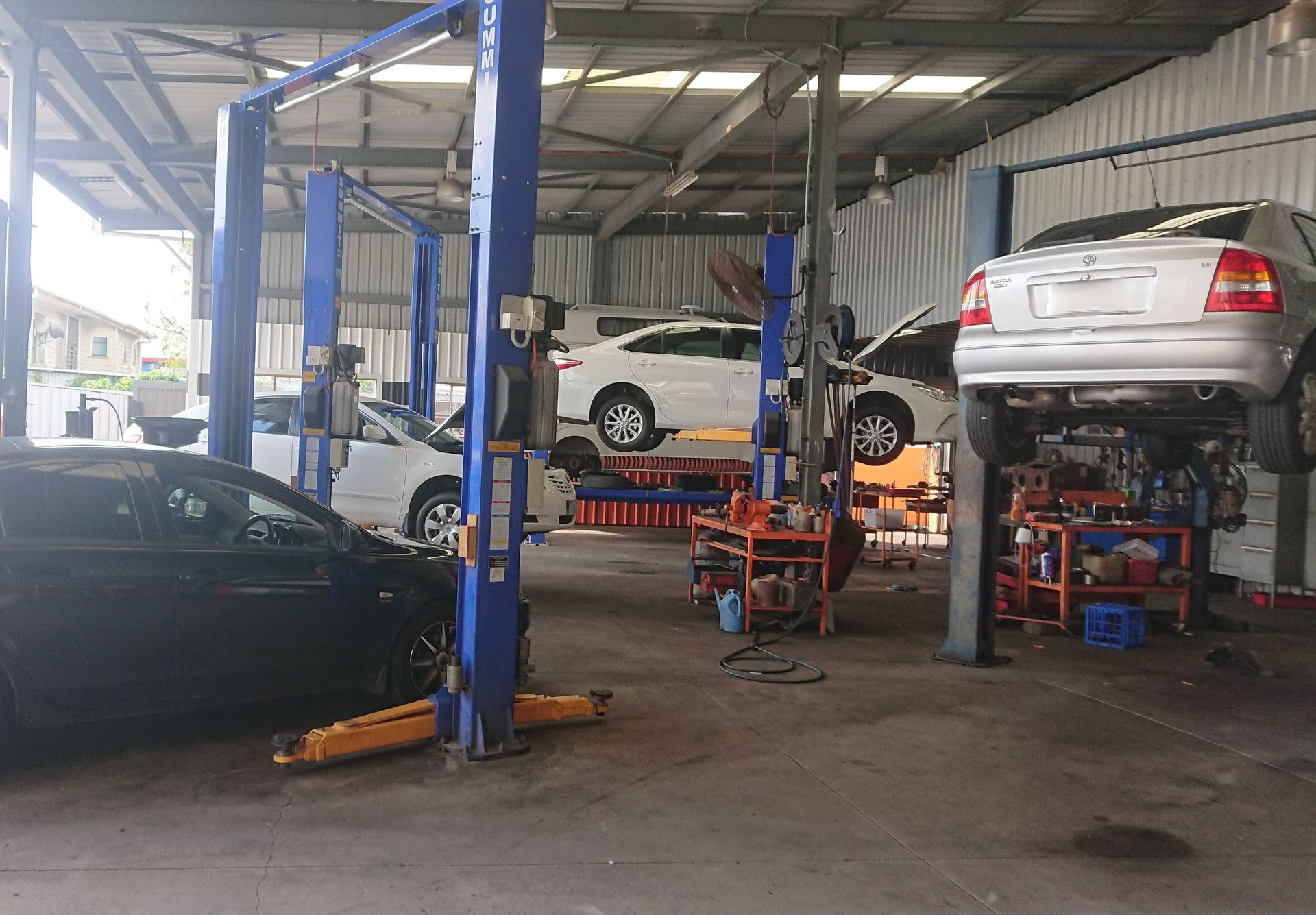Busy Auto Repair Shop with Cars Being Lifted