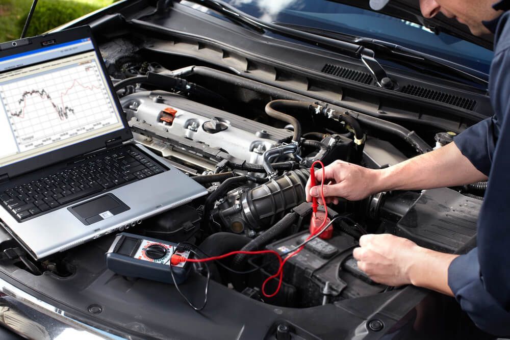 Mechanic Inspecting A Car Using A Device