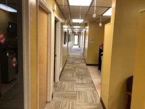 Commercial hallway with newly installed carpet tile flooring by flooring contractors in Plantation, FL.