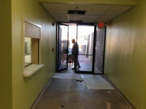 Flooring professionals prepping a commercial entryway for installation in Plantation, FL.
